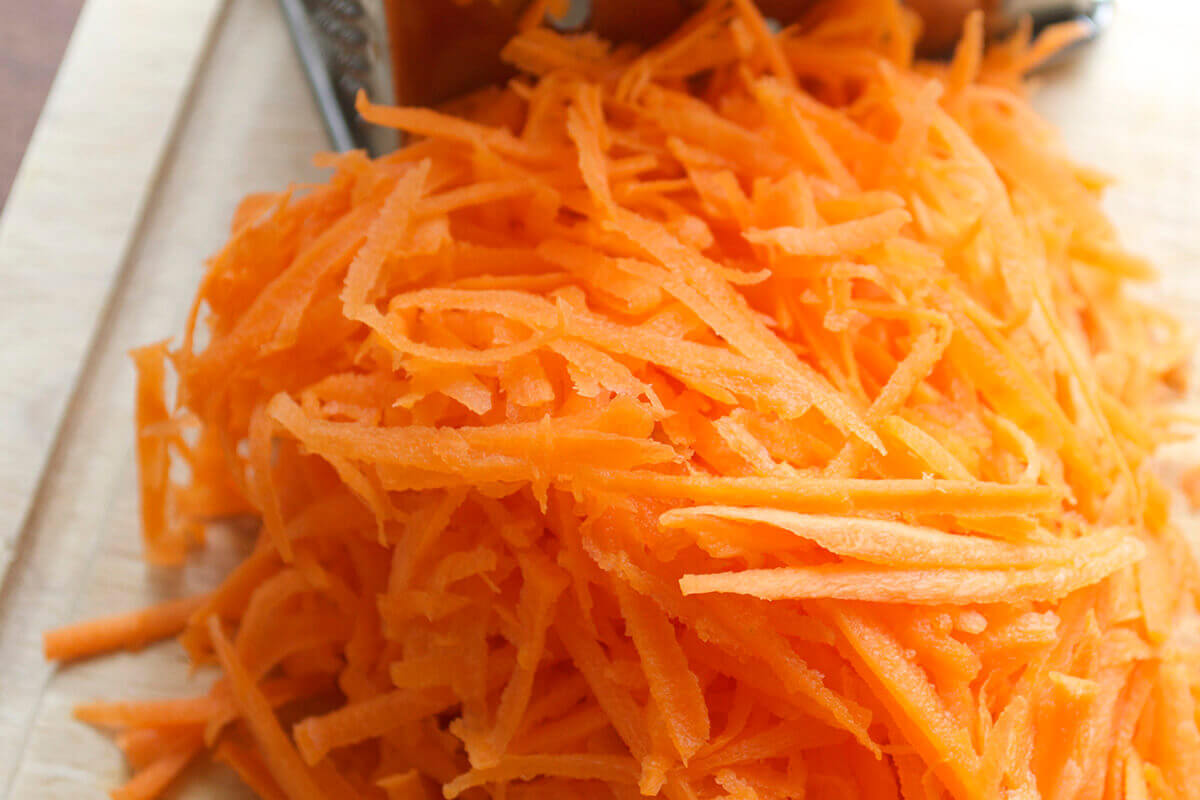 A chopping board with grated carrot