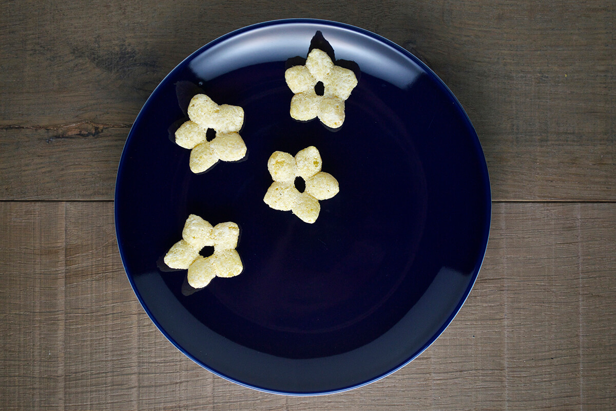Organix melty cheese stars placed on dark blue plate to create night sky