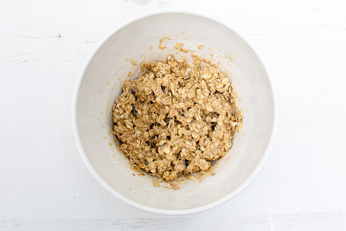 A bowl of mashed banana combined with peanut butter, milk, maple syrup, vanilla, oats, flour and Organix Gummies