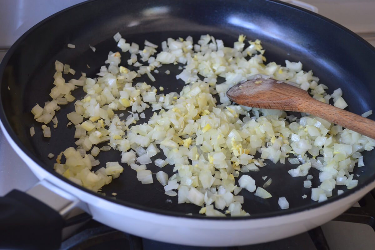 A frying pan of chopped onion, ginger and garlic