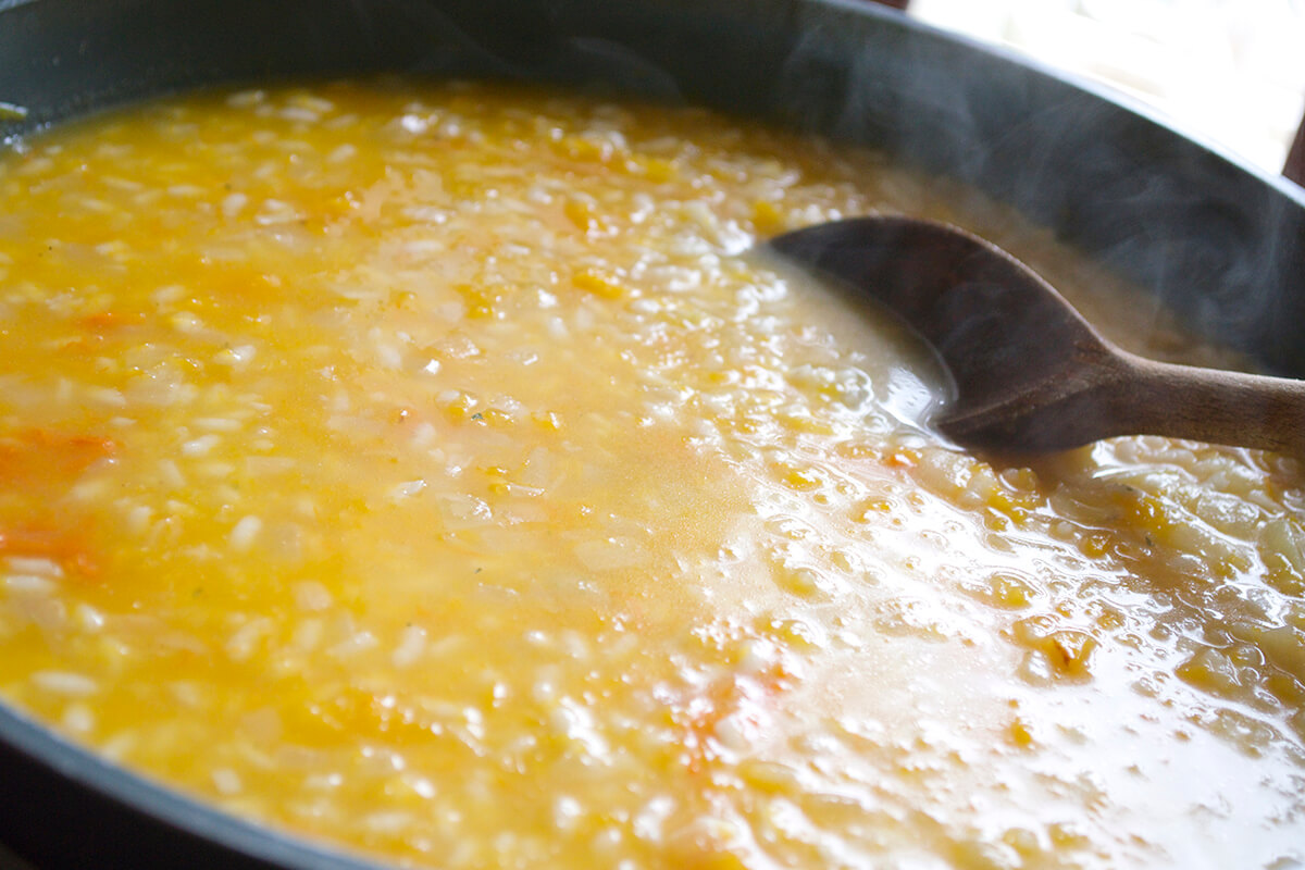 Arborio rice being cooked with pureed butternut squash