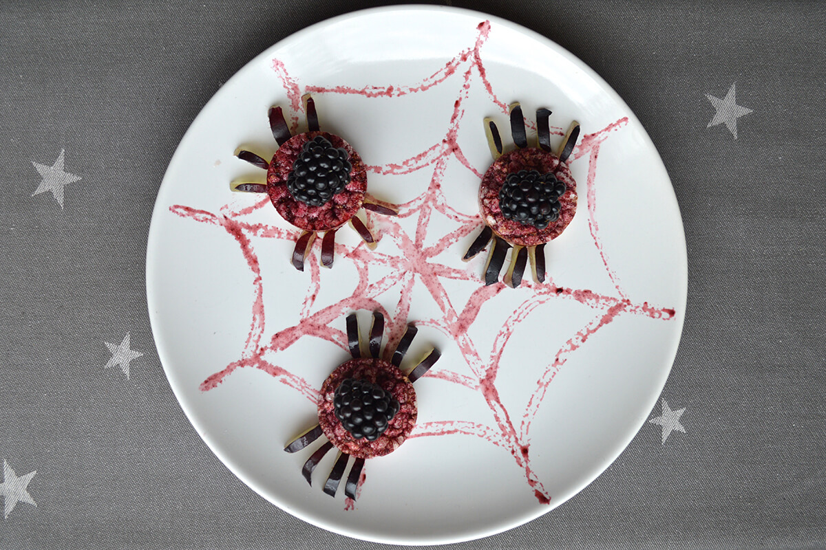 To complete the spiders, 4 grape slices are arranged on either side of each of the rice cakes