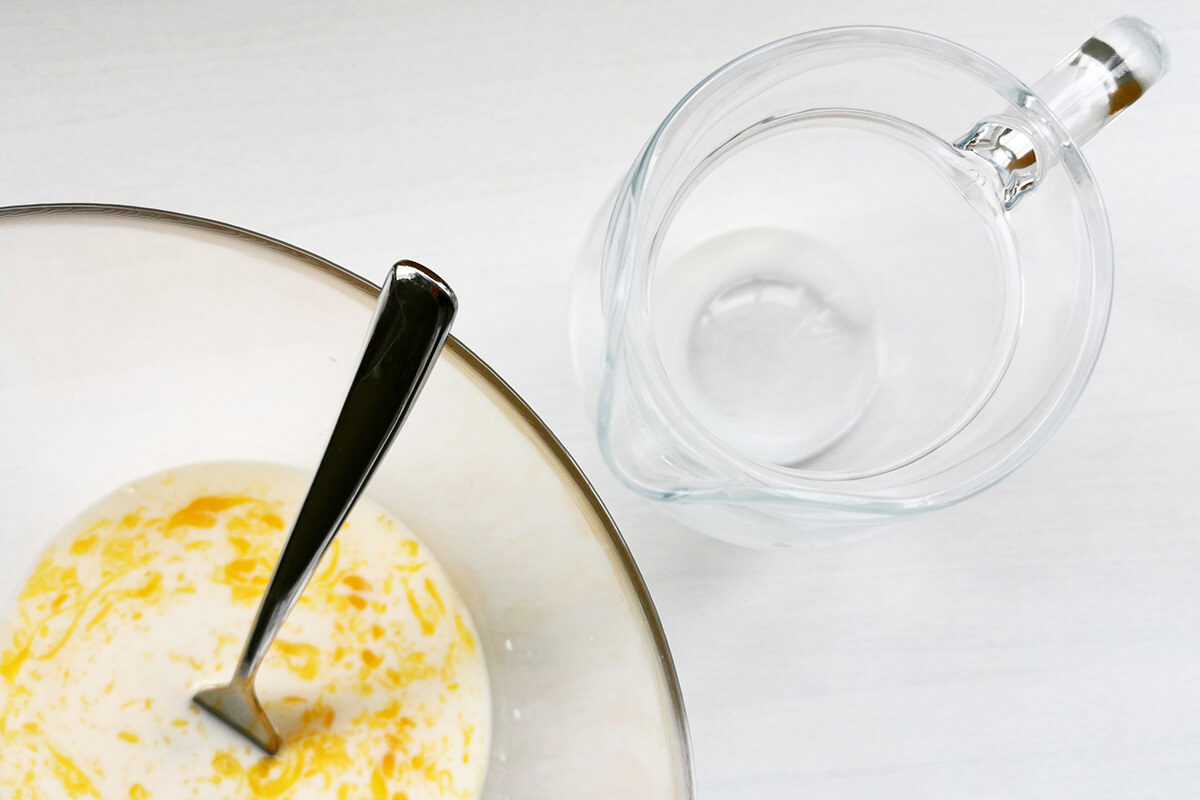 A glass bowl of egg and milk