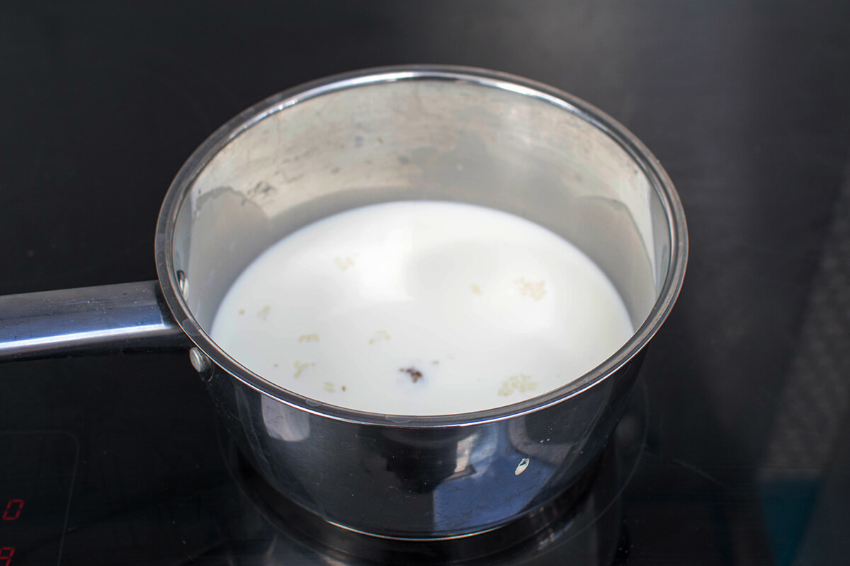 A saucepan of rice, milk and vanilla on the hob